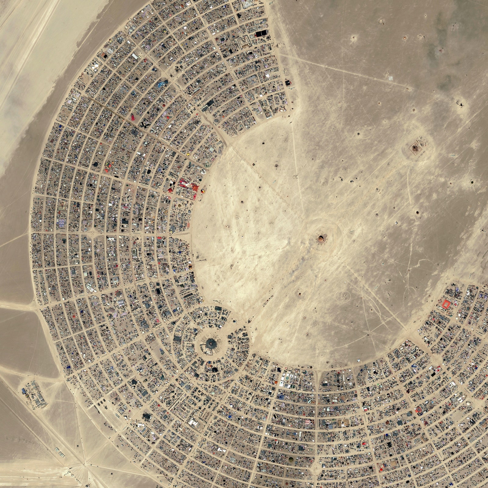 Aerial view of a tents arranged in a geometric shape in a desert landscape during Burning Man Festival