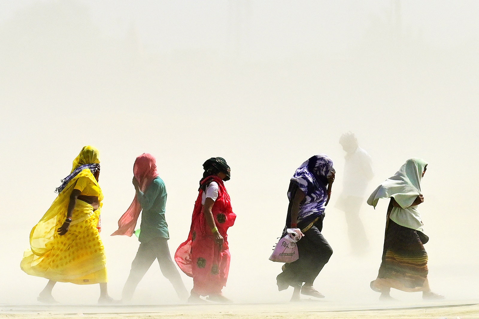 People walking in a line outside in a dusty hot landscape