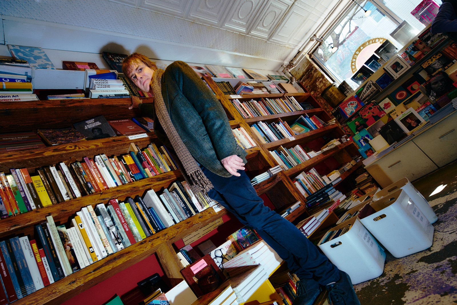 Andy Hunter standing on a step stool next to a bookshelf in a bookstore
